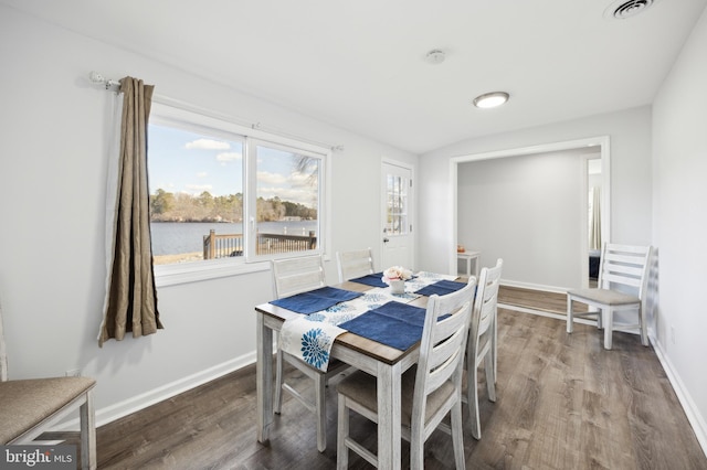 dining room with visible vents, baseboards, and wood finished floors