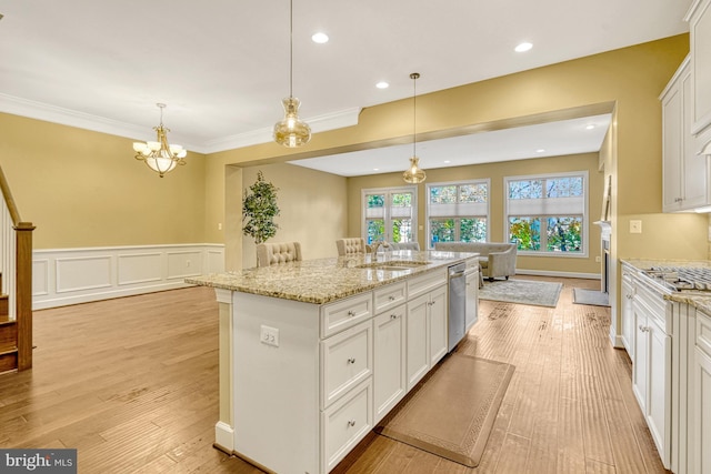 kitchen featuring a center island with sink, light wood-style flooring, white cabinets, a sink, and dishwasher