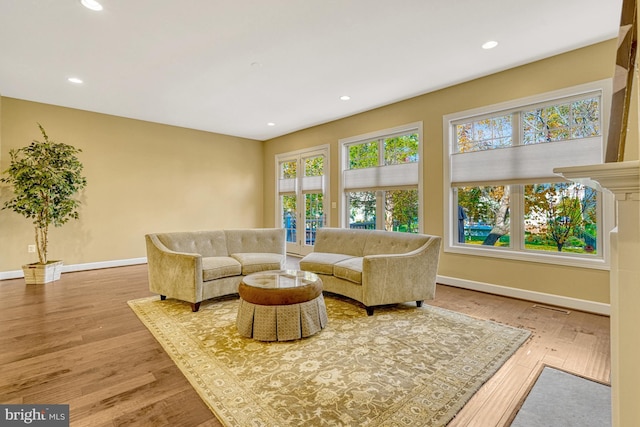 living room featuring visible vents, baseboards, wood finished floors, and recessed lighting