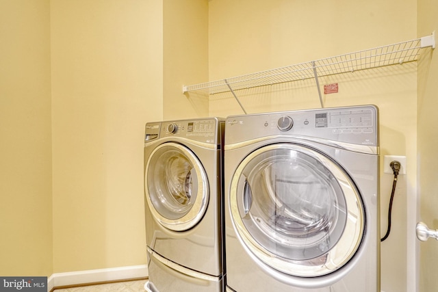 laundry area featuring laundry area, washing machine and dryer, and baseboards