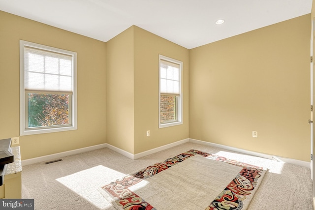 carpeted bedroom with recessed lighting, multiple windows, visible vents, and baseboards