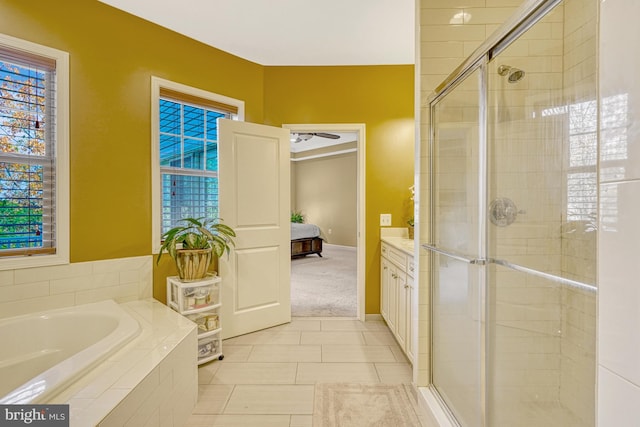 full bathroom featuring a stall shower, tile patterned flooring, vanity, and a bath