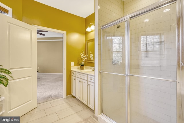 bathroom featuring baseboards, a tile shower, and vanity