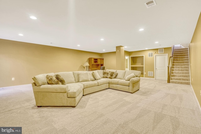 living area with carpet floors, recessed lighting, visible vents, and stairs