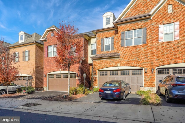 view of property with an attached garage, driveway, and brick siding