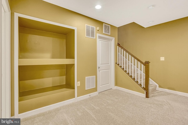 interior space with carpet floors, stairway, and visible vents