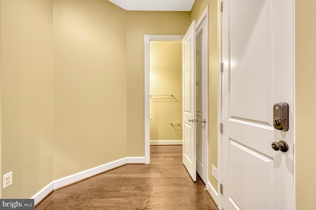 hall with wood finished floors and baseboards