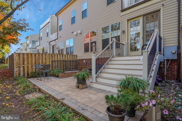 entrance to property featuring a patio area, a residential view, and fence