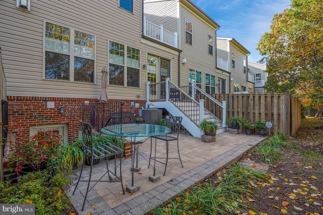 view of patio featuring outdoor dining area, fence, and central air condition unit