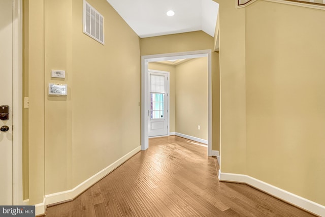 corridor with visible vents, baseboards, and wood finished floors