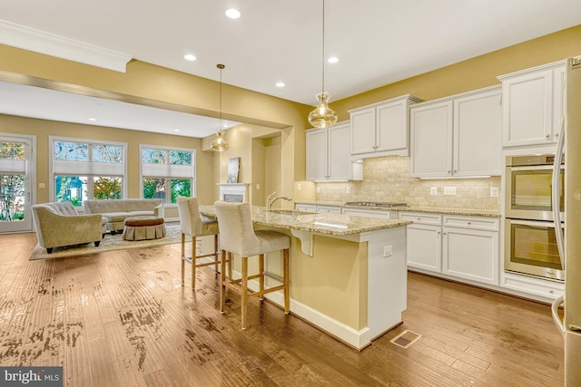 kitchen featuring white cabinetry, visible vents, appliances with stainless steel finishes, and decorative backsplash