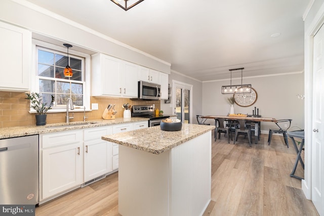 kitchen with appliances with stainless steel finishes, a sink, and white cabinets