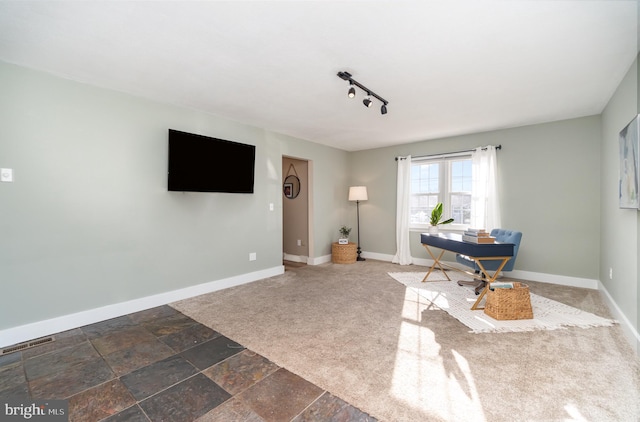 home office with visible vents, baseboards, and stone tile flooring