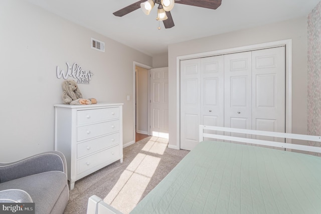 bedroom featuring baseboards, visible vents, a ceiling fan, light colored carpet, and a closet