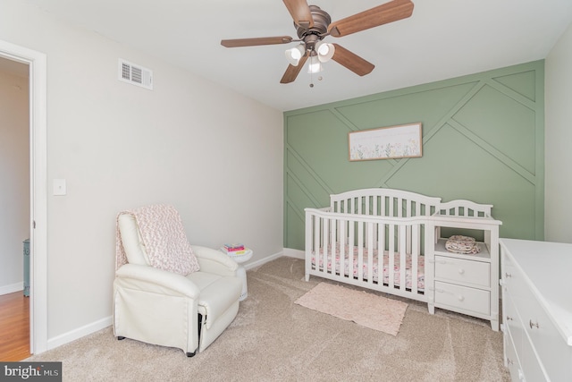 bedroom featuring carpet floors, visible vents, a crib, and baseboards