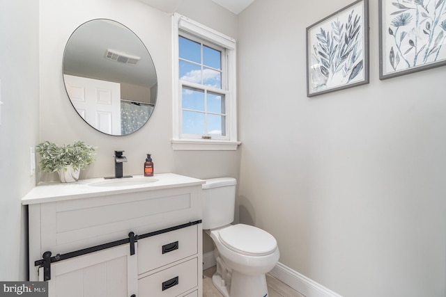 full bathroom with baseboards, visible vents, vanity, and toilet