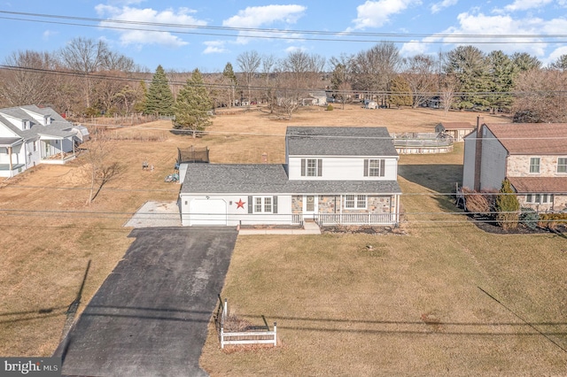 view of front of house with covered porch, a garage, fence, driveway, and a front yard