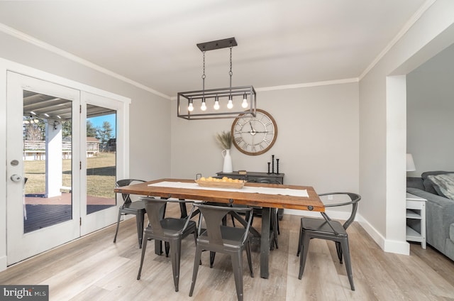 dining room featuring ornamental molding, light wood-style flooring, and baseboards