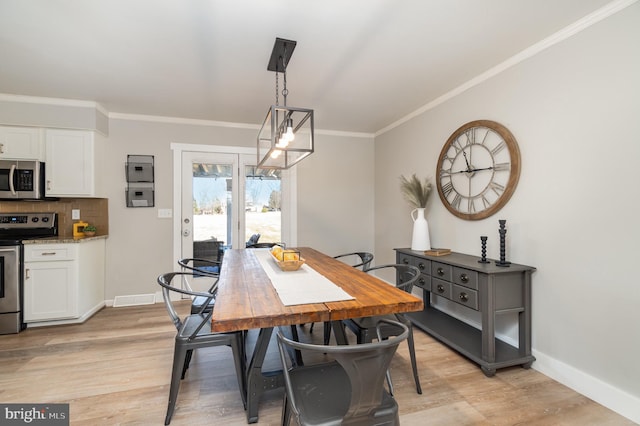 dining room with crown molding, light wood-style flooring, and baseboards