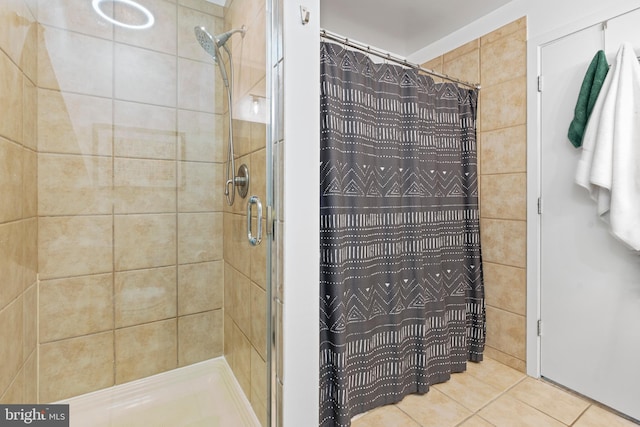 bathroom with a shower stall and tile patterned floors