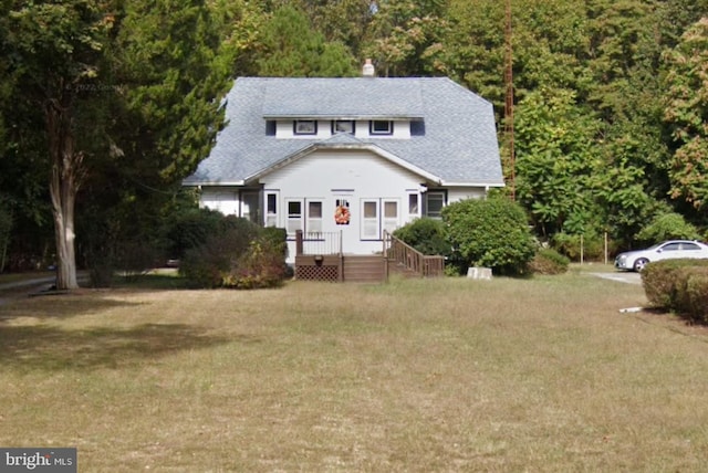 bungalow-style home with a shingled roof and a front lawn