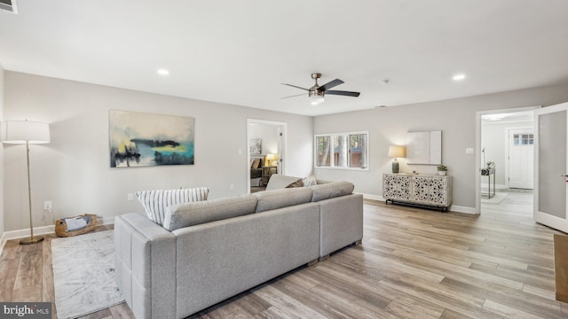 living room featuring ceiling fan, recessed lighting, light wood-style flooring, and baseboards