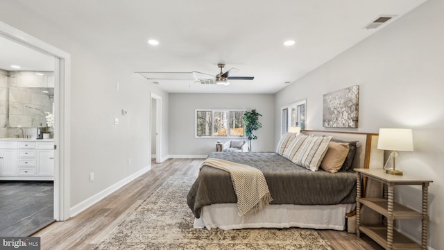 bedroom featuring wood finished floors, a sink, visible vents, and baseboards