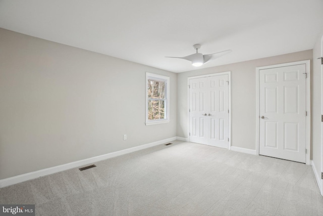 unfurnished bedroom with baseboards, visible vents, a closet, and light colored carpet