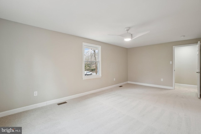 empty room featuring light carpet, baseboards, visible vents, and ceiling fan