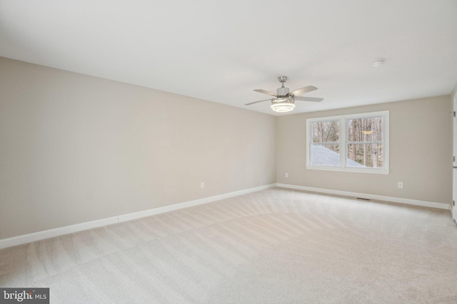 unfurnished room with light colored carpet, ceiling fan, visible vents, and baseboards