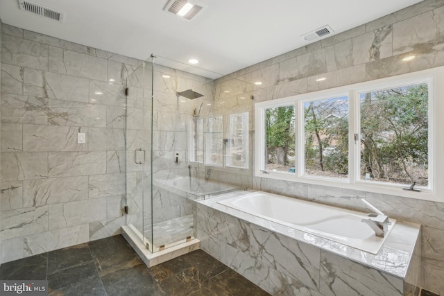 bathroom with a bath, a stall shower, and visible vents