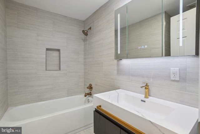 bathroom featuring tasteful backsplash, visible vents, shower / bathtub combination, vanity, and tile walls