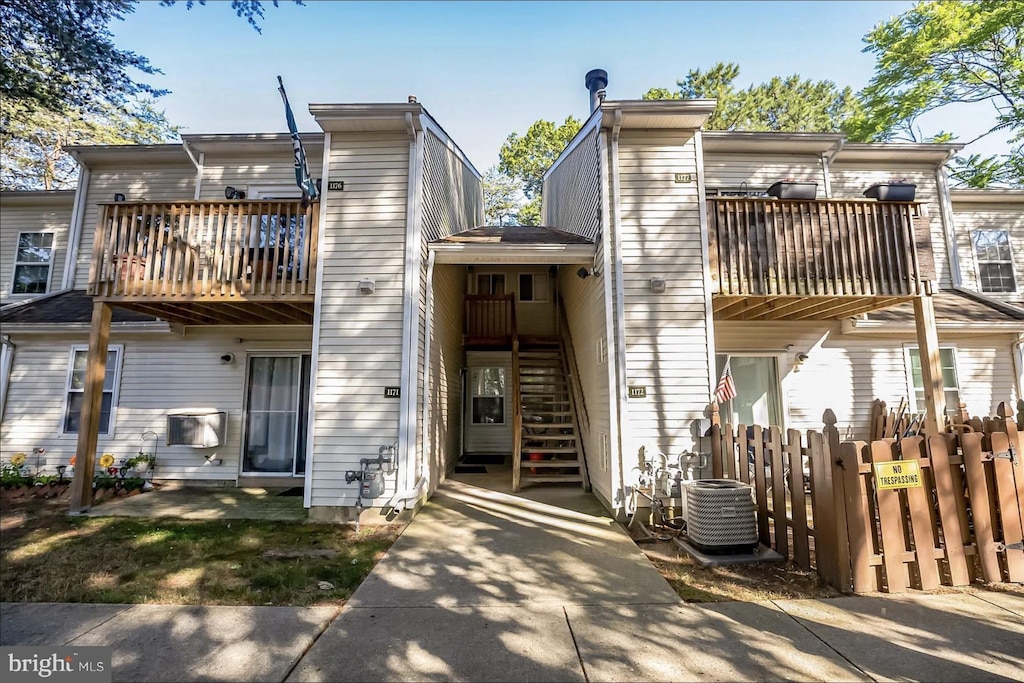 exterior space featuring stairs, fence, and central air condition unit