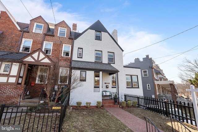 view of front facade with a fenced front yard and brick siding