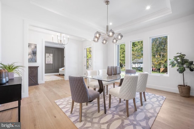 dining space with a tray ceiling, light wood finished floors, recessed lighting, a chandelier, and baseboards