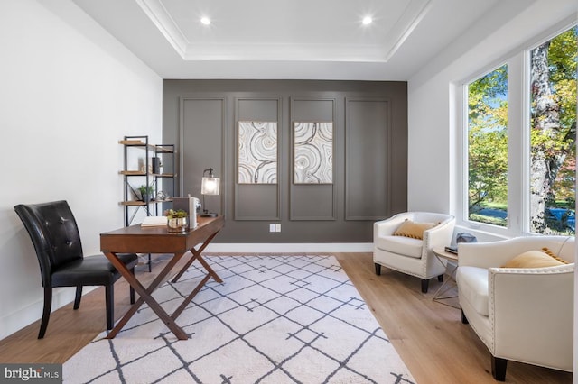 foyer with light wood finished floors, a tray ceiling, and recessed lighting