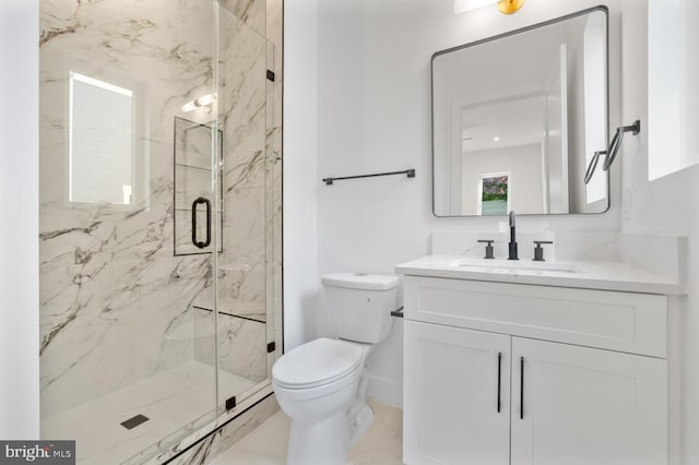 bathroom featuring marble finish floor, a marble finish shower, toilet, vanity, and baseboards