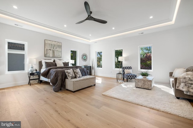 bedroom featuring baseboards, visible vents, a raised ceiling, wood finished floors, and recessed lighting