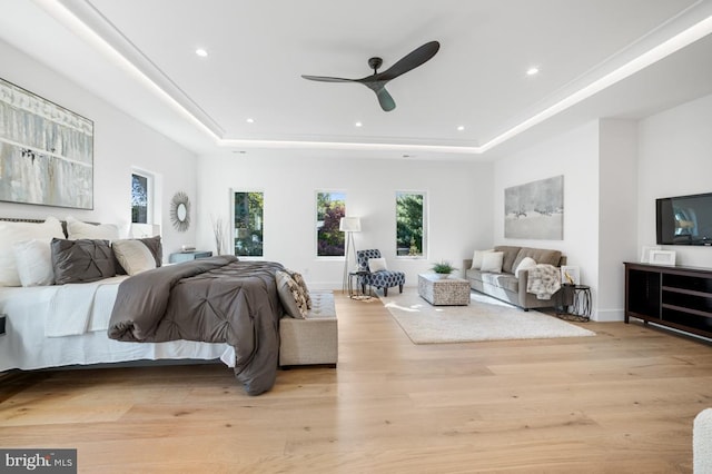 bedroom with baseboards, a tray ceiling, light wood-type flooring, and recessed lighting