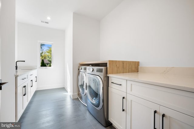 washroom with washer and clothes dryer, cabinet space, visible vents, a sink, and baseboards