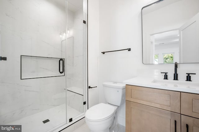 bathroom featuring vanity, a marble finish shower, and toilet