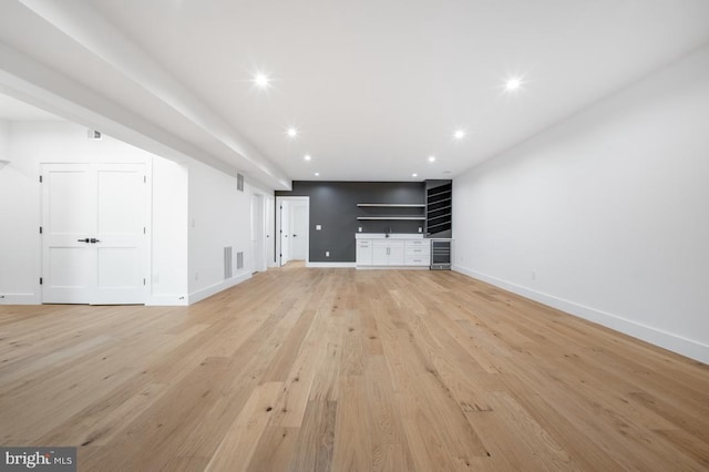 unfurnished living room with baseboards, recessed lighting, and light wood-style floors