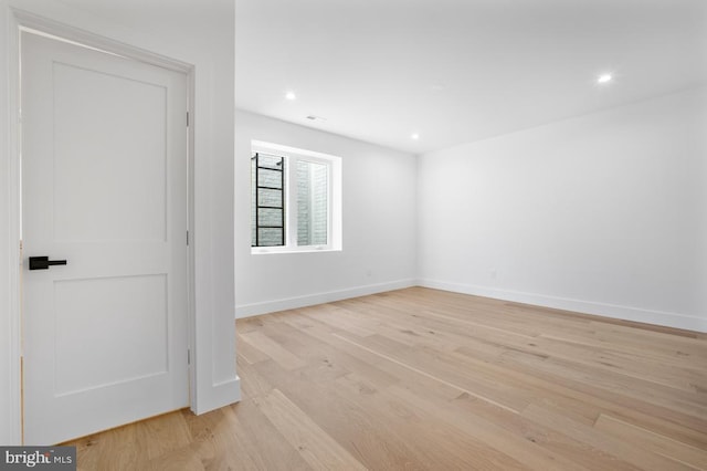 spare room with baseboards, recessed lighting, and light wood-style floors