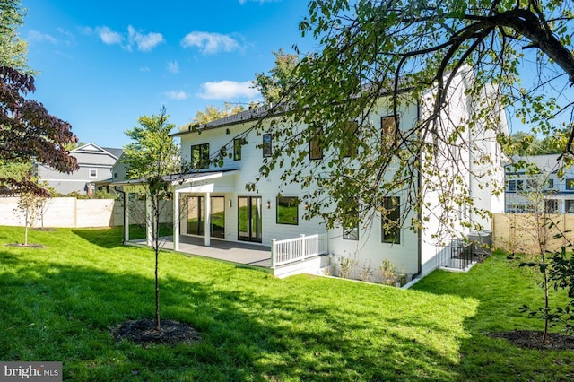 back of property featuring a yard, a patio, and a fenced backyard