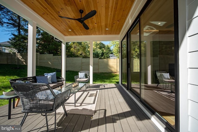 wooden deck featuring ceiling fan, fence, and an outdoor living space