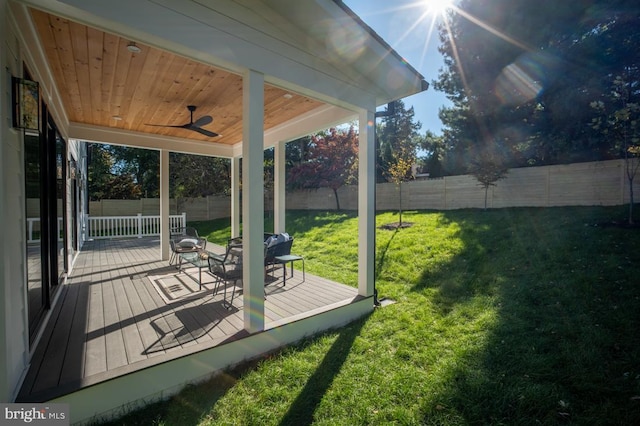 view of yard with a fenced backyard, a wooden deck, and a ceiling fan