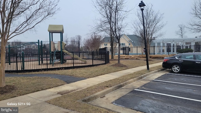 communal playground with a residential view and fence