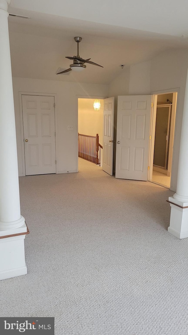 interior space with lofted ceiling, ornate columns, ceiling fan, and carpet flooring