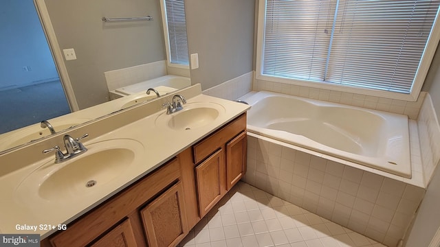 bathroom with a garden tub, double vanity, a sink, and tile patterned floors