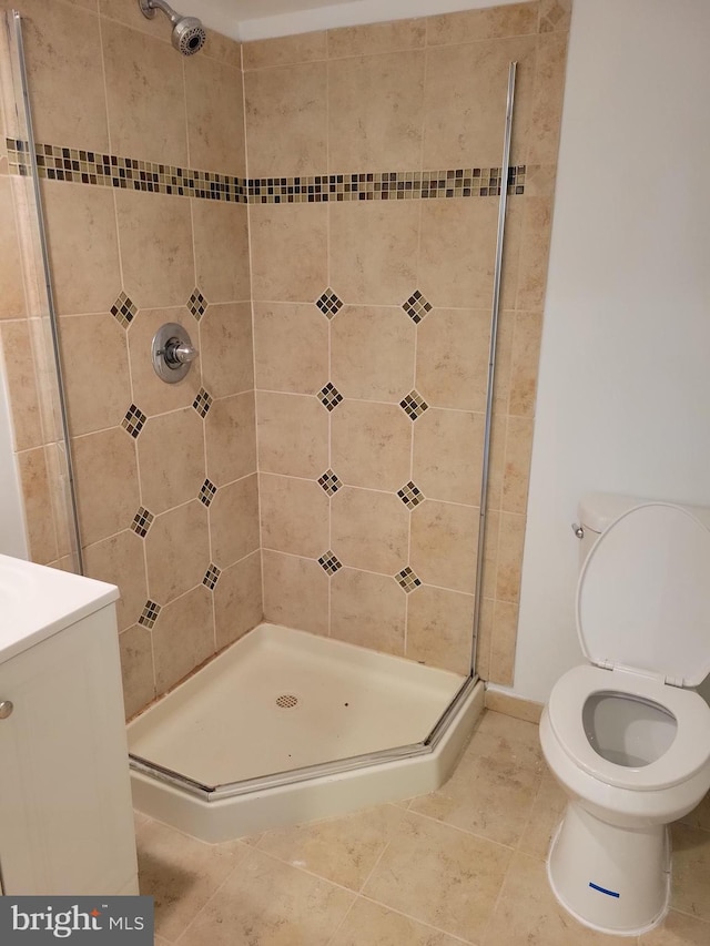 bathroom featuring a shower stall, toilet, and tile patterned floors